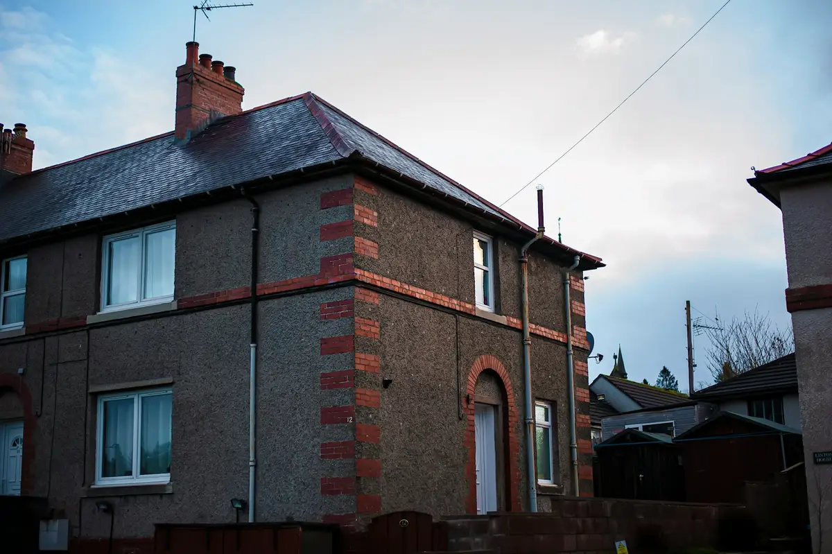 Interwar semi-detached house with brick quoins and white uPVC windows